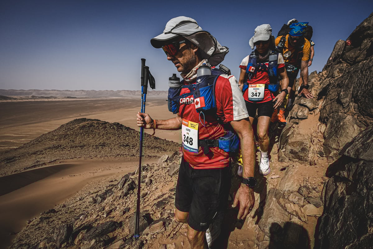 three people hiking in the sahara