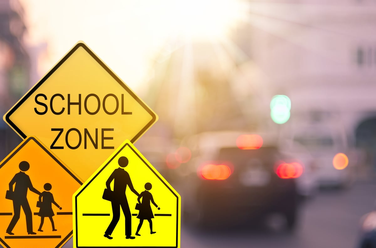 three school zone crossing signs